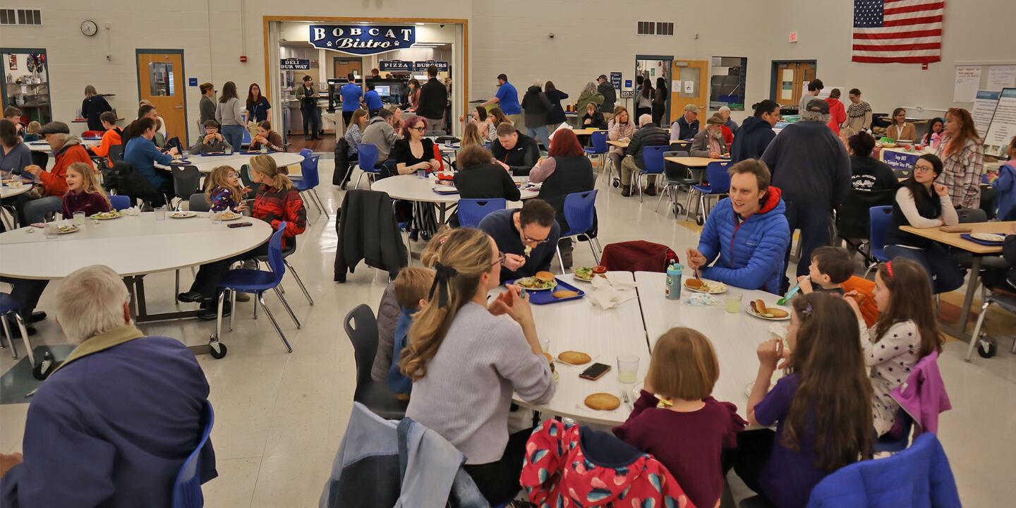 A photo of a large group of people eating their meal in the Oyster River High School Cafeteria
