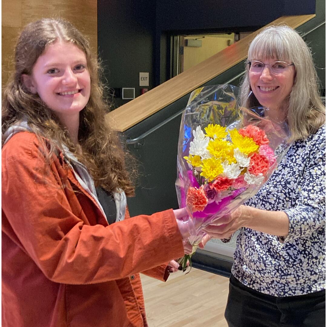Student representative Paige Burt is seen on the left accepting a bouquet of flowers from School Board Chair Denis Day during her last board meeting in June 2023.